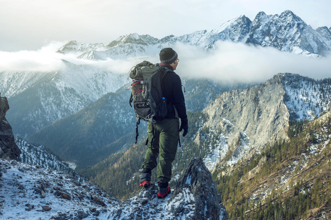 A man standing on a mountain, looking out.