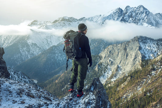 A man standing on a mountain, looking out.